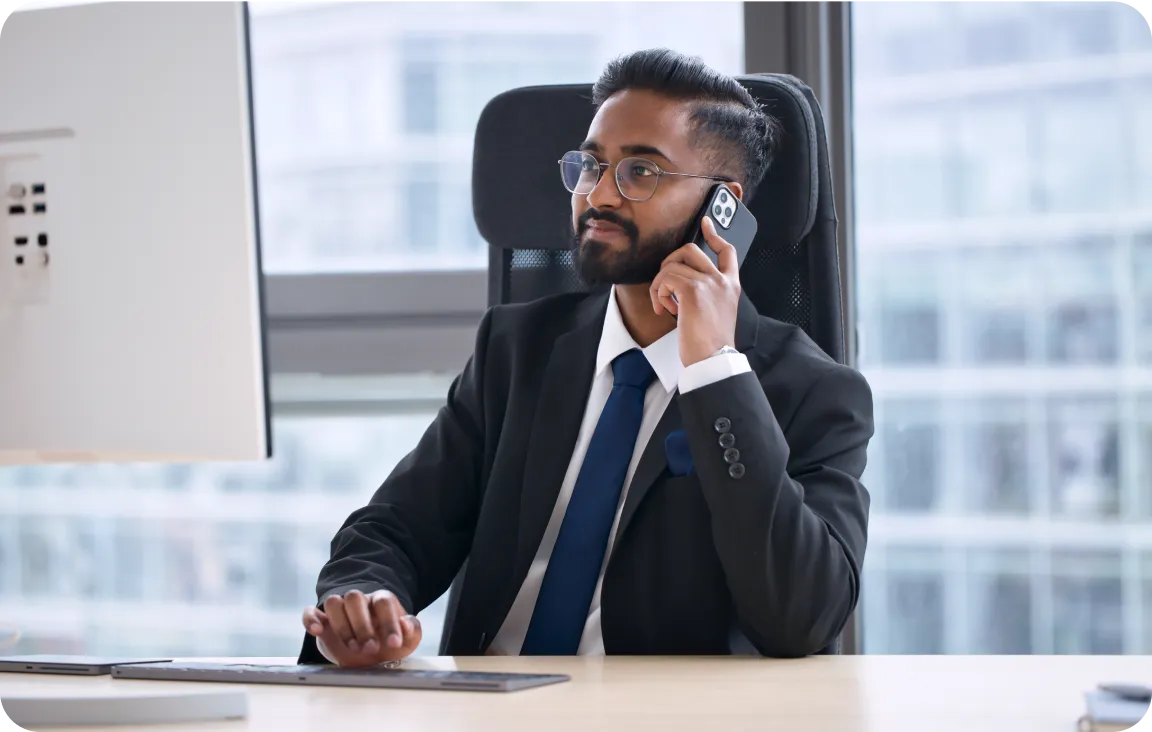 Business professional using a smartphone at a desk in a modern office - Havedevs, an outstaffing agency for hiring external developers. Enhance your tech team with expert developers from Havedevs.