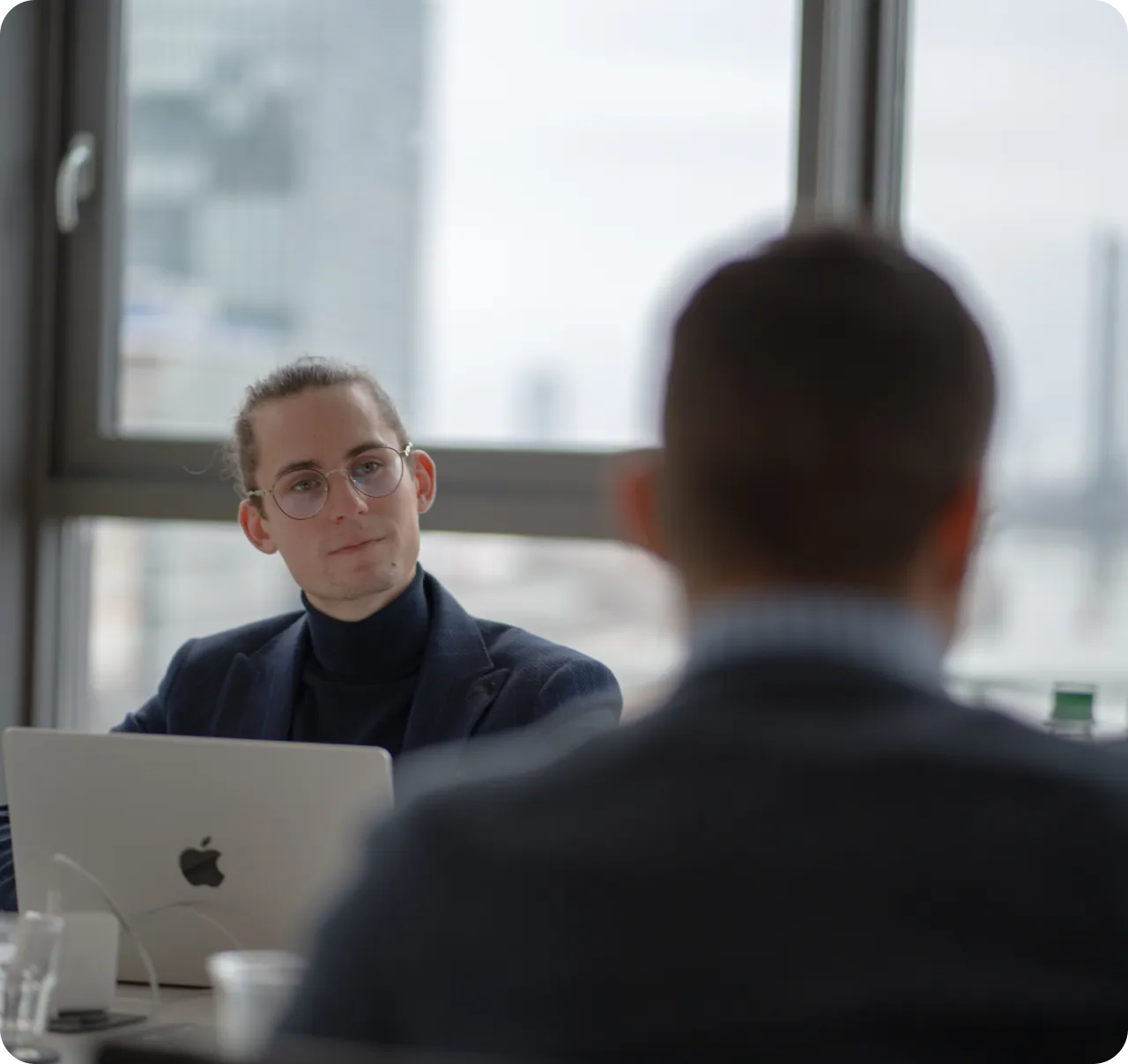 Professional meeting in a modern office, with one person using a laptop - Havedevs, specializing in web app development. Boost your business with cutting-edge web application solutions from Havedevs.