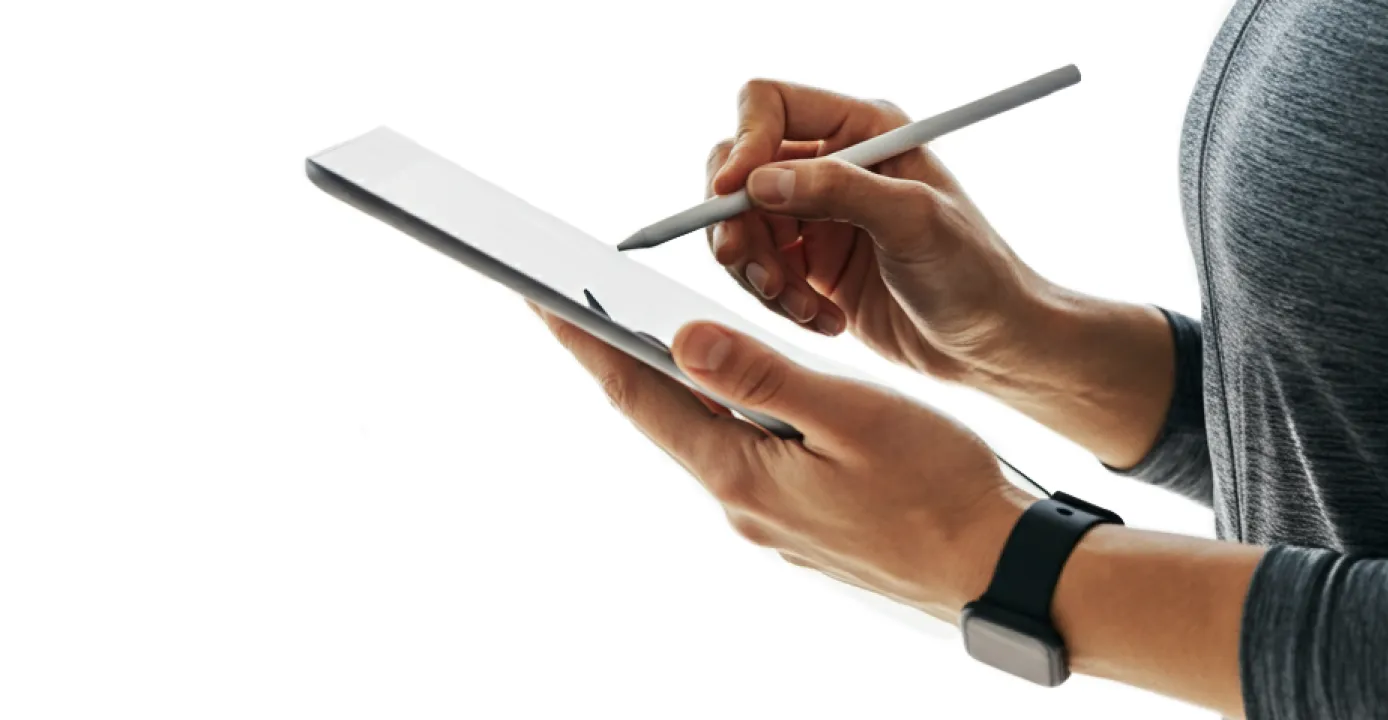 A person writing on a tablet with a pen